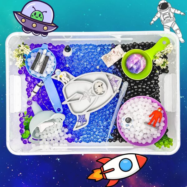 Space-themed craft kit spread across a transparent tray with beads, tools, and decorations, plus a cartoon UFO and astronaut clip art in the background.